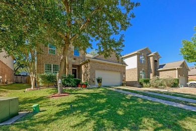 Traditional-style house with brick siding, driveway, and an attached garage