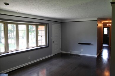 Additional view of the living room and front entryway.  Hallway leads down to the bedrooms.