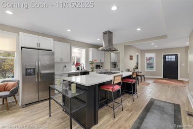 Kitchen with white cabinets, stainless steel fridge with ice dispenser, plenty of natural light, recessed lighting, and light wood finished floors