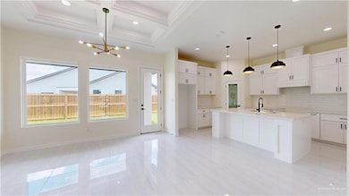 Kitchen featuring coffered ceiling, a chandelier, decorative backsplash, a center island with sink, and recessed lighting