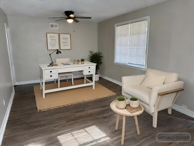 Office space with dark hardwood / wood-style floor