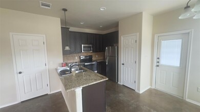 Kitchen with stainless steel appliances, concrete