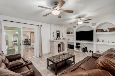 Living area featuring baseboards, ceiling fan, bui