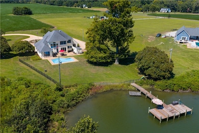 Aerial view of sparsely populated area with a pool area and a large body of water