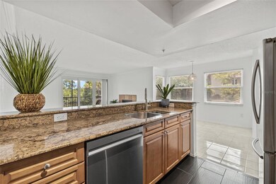Open Kitchen with Granite Breakfast Bar. Enjoy seamless flow from the kitchen into the bright living space, perfect for entertaining or relaxing at home.