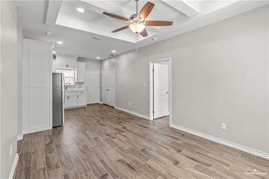 Unfurnished living room featuring light wood-style flooring, baseboards, and ceiling fan