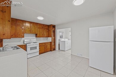 Kitchen with white appliances, sink, washing machi