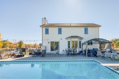 Rear view of house with outdoor dining area, a chimney, a patio, an outdoor living space, and a gazebo