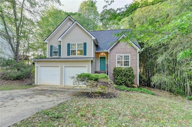 Split level home featuring concrete driveway, bric