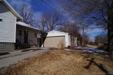 Side porch with entrance to the kitchen and 2 car