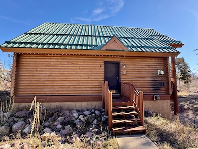 Log cabin with log exterior and a metal roof