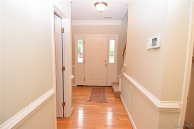 Hardwood foyer with sidelights and a full glass st