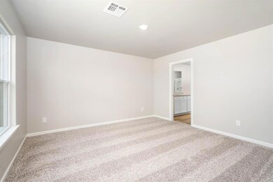 The primary bedroom is spacious with large windows