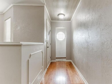 Doorway to outside with crown molding, hardwood / wood-style flooring, and a textured wall