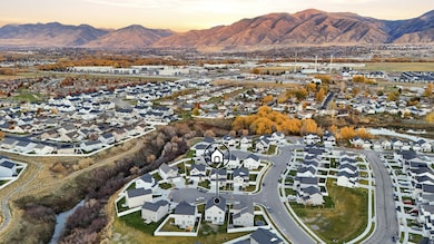 Aerial view of property's location with nearby suburban area and Wellsville mountains in the background