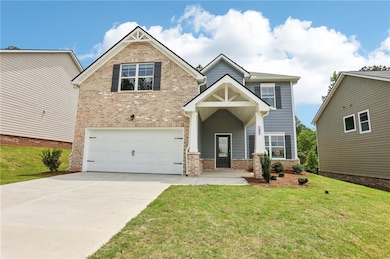Craftsman-style home featuring brick siding, an attached garage, concrete driveway, and a front lawn