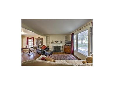 Large living room with rich wood floors and firepl