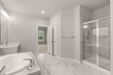 This additional view of the primary bath showcases the large walk-in shower with tile surround.