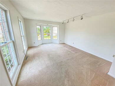 The light and bright living room features a bay wi