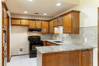 Kitchen featuring black electric range, a sink, un