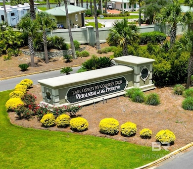 Community / neighborhood sign featuring a lawn and fence