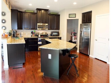 Kitchen has stainless steel appliances, wood floor