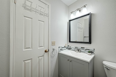 The bathroom has a granite-topped sink and a vanit