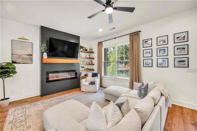 Living area with a fireplace, ceiling fan, wood finished floors, and recessed lighting