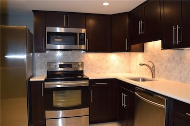 The kitchen features dark wood shaker cabinets, qu