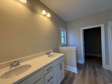Full bathroom with double vanity, a walk in closet