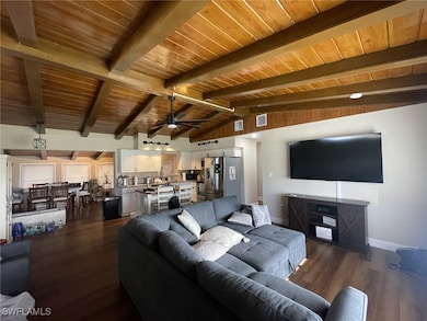 Living area with visible vents, dark wood-type flo