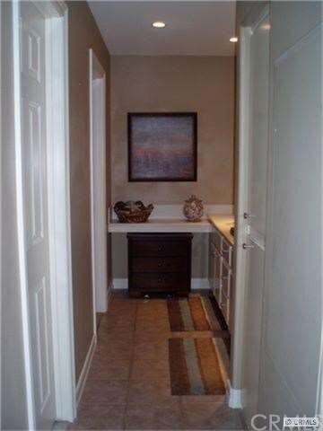 Hallway leads to walk-in closet, built in linen cl