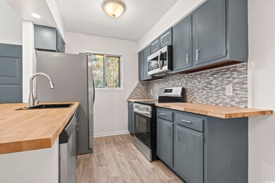 Kitchen featuring wooden counters, stainless steel