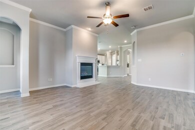 Unfurnished living room with ornamental molding, ceiling fan, and light wood-type flooring