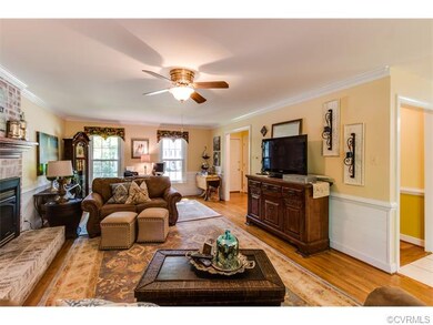 The living room features hardwood flooring, crown 