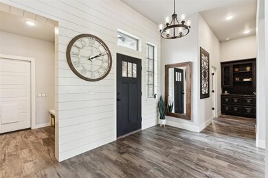 Foyer with a chandelier, wood finished floors, and