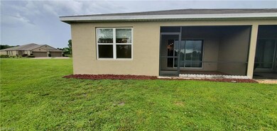 Rear view of property with a lawn, stucco siding, and a sunroom