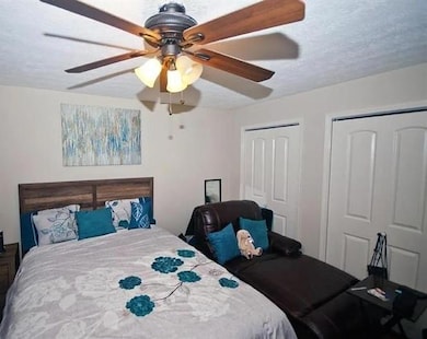 Bedroom with two closets, a textured ceiling, and 