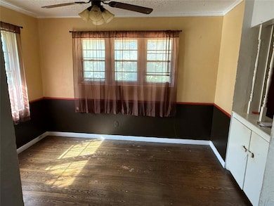 Unfurnished room featuring crown molding, dark wood-style floors, ceiling fan, and a textured ceiling