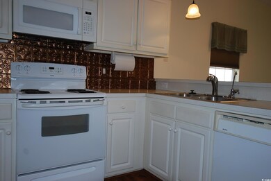 Kitchen featuring pendant lighting, white applianc