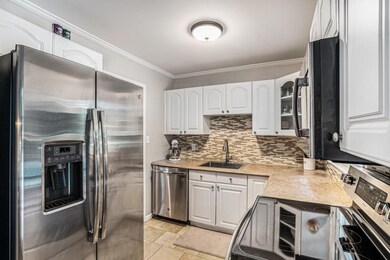The adjacent Dining Area flows into a stylish Kitchen featuring White Cabinets and Stainless Steel Appliances, making it perfect for both Everyday Living and Entertaining
