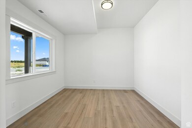 Empty room featuring light wood-type flooring and baseboards