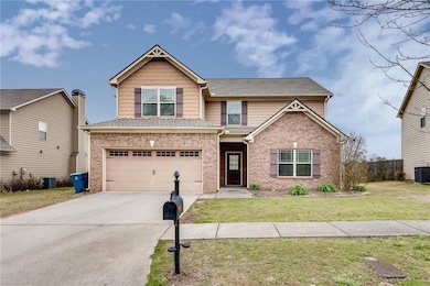 View of front of home featuring brick siding, attached garage, concrete driveway, and roof with shingles