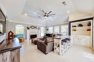 Wood burning fireplace, custom built ins, and large windows for natural lighting.