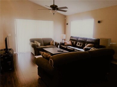 Living area has sliders to patio, wood flooring an