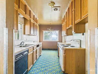 Kitchen with dishwasher, electric range, tasteful backsplash, light countertops, and a chandelier