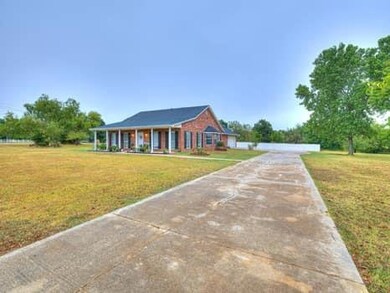 View of front of home with concrete driveway and a front lawn