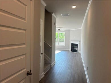 Hallway with dark wood-style floors, ornamental molding, and recessed lighting