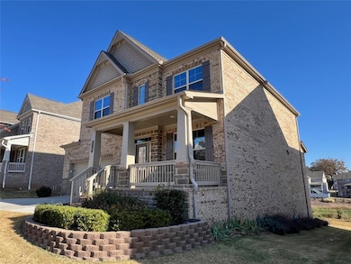 Craftsman house featuring a porch, brick siding, and concrete driveway