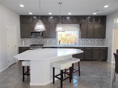 Kitchen with a breakfast bar, light countertops, s